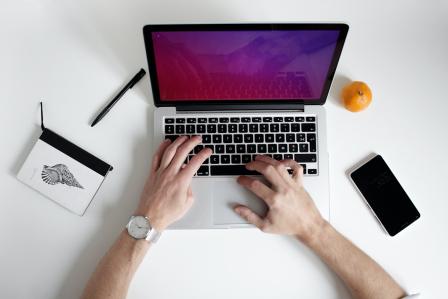 Individual typing on laptop. 