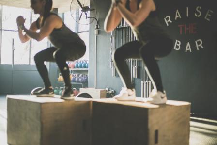 Two women doing box squats.