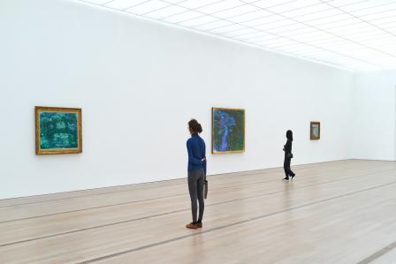 Two women staring at art pieces.