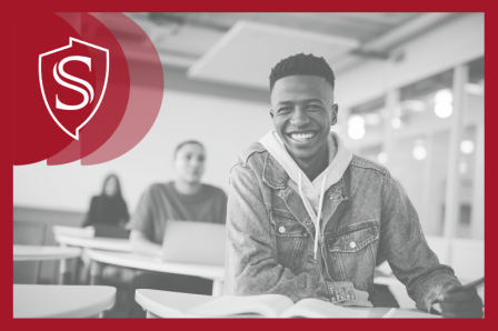 Three students sitting in a row. The first is fully in focus, with the second and third out of focus.