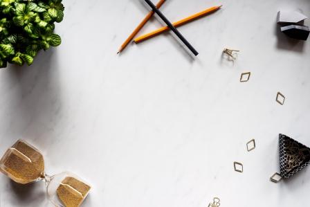 Timer, pencil, and staples on a white desk