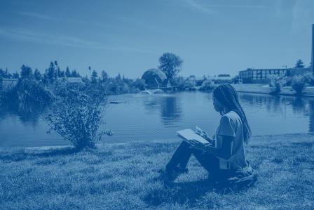 Person sitting by a lake
