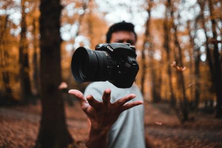 Someone throwing a camera in the air