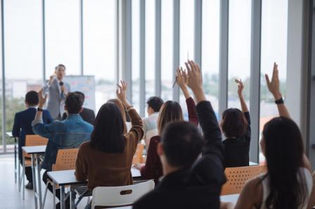 People raising their hands at a presentation