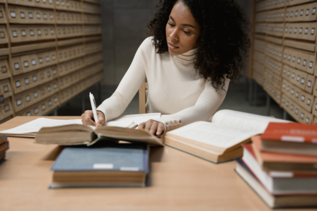 Person in a library writing in a notebook