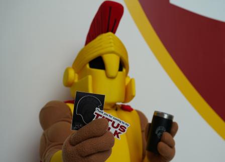 Titus Mascot holding stickers and tumbler