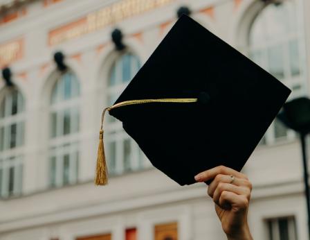 Someone holding up a graduation cap