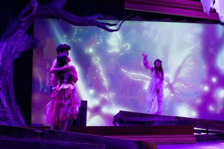 Student actors on stage with set, costume and lights