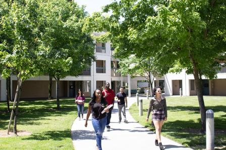 photo of campus housing with trees and students