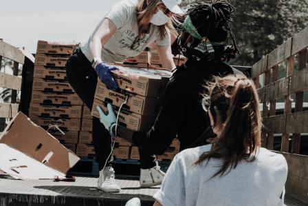 person passing a box to another person 