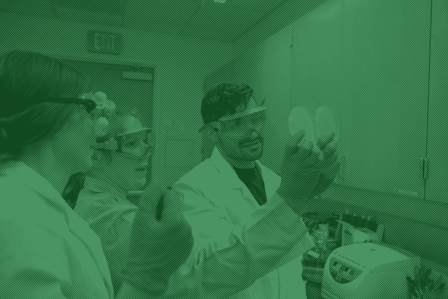 Students in lab coats, handling lab equipment