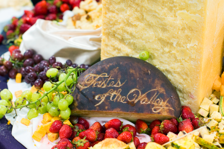 Charcuterie board with "Tastes of the Valley" carved out in a cheese block