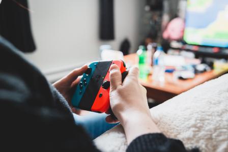 person holding a nintendo swtich joycon controller 