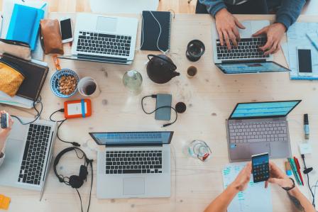 people sitting down at a table with computers