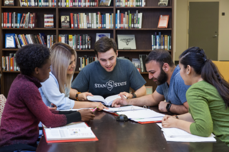 5 students at a table studying