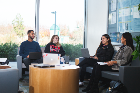 Four students studying inside a classroom building.