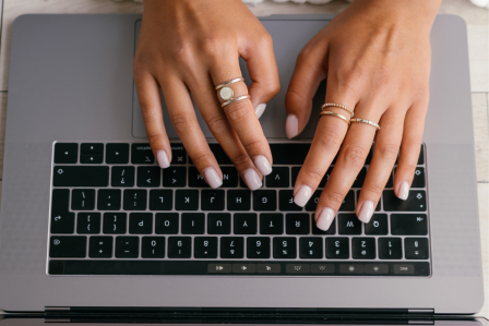 hands typing on a laptop