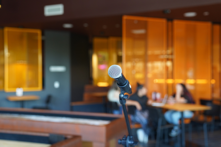 a microphone on stage with a blurry couple in the background.