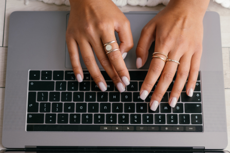 Hands typing on a laptop keyboard.