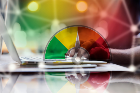 a meter representing credit scor in front of a laptop