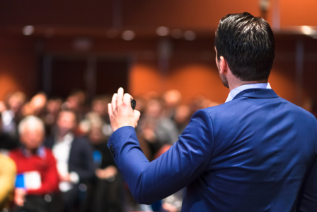 a businessman giving a presentation to a small crowd