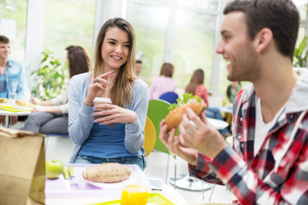two students eating lunch at a table. 