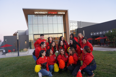 A group of students in a group photo in front of the Student Center.