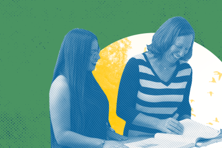 Two women talking and looking at a book