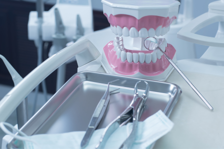 dental equipment on an exam table with a model set of teeth