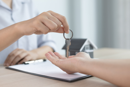 A person handing keys to another person