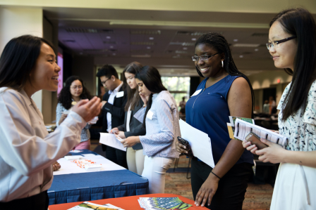 A diverse group of individuals gathered around a table, engaging in discussion.