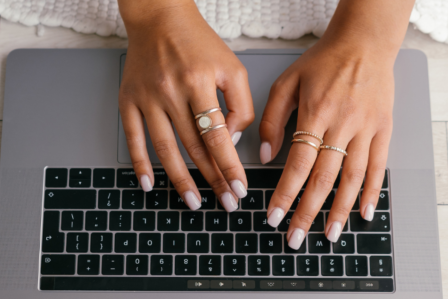 Hands typing on a computer