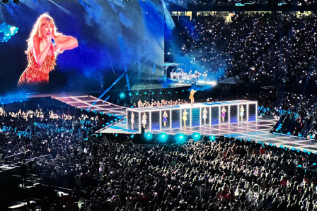 A large audience is engaged in a concert, focused on the performer on stage.