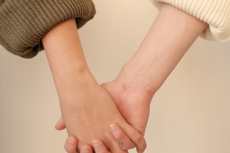Two individuals holding hands.