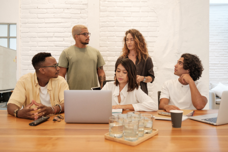 A group of diverse employees work in a group setting.