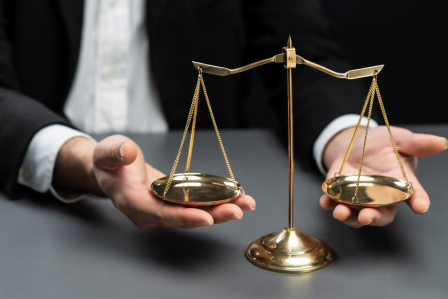 A set of hands holds a scale with two weights
