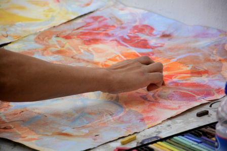 Student painting with oil pastel colors.