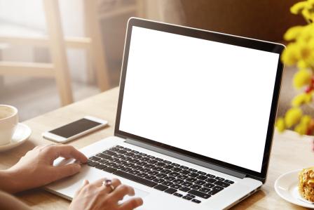 Hands typing on a laptop