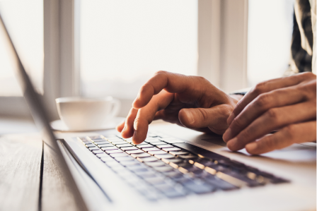 Hands typing on a computer
