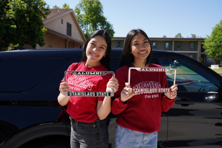Stan State students holding license plate frames.