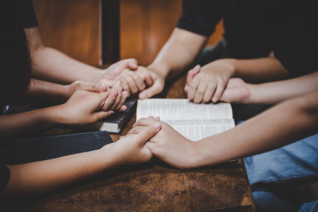 Group holding hands and praying