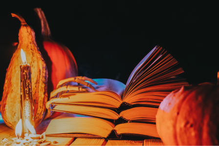 Books with pumpkins and candles around them