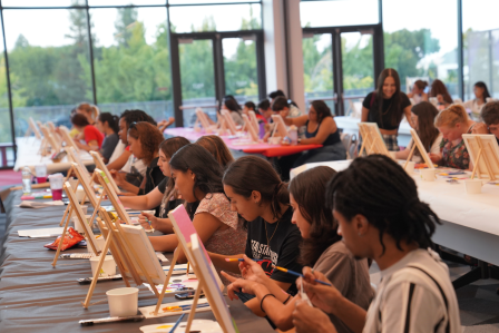 Students are seen painting canvases at a recent paint night event at the Student Center