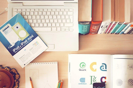 Image of a desk with books and a laptop