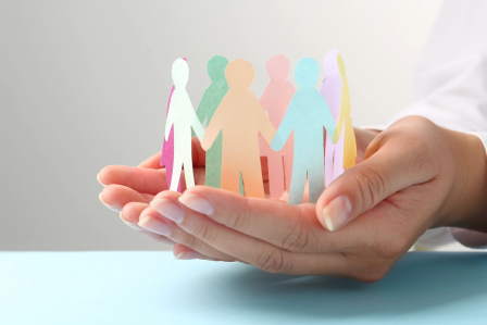 Hands holding paper people