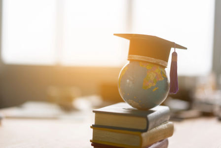 Graduation cap with globe and books 