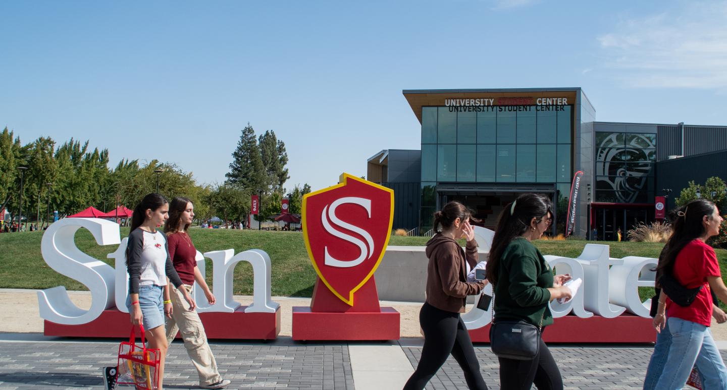 Students walking across the Quad with the Student Center in the background.
