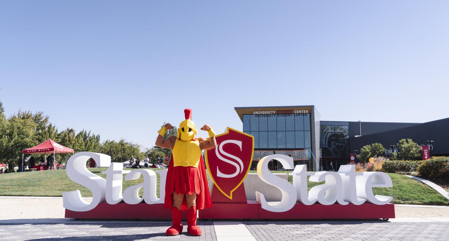 Titus standing in front of the Stan State sign in front of the University Student Center