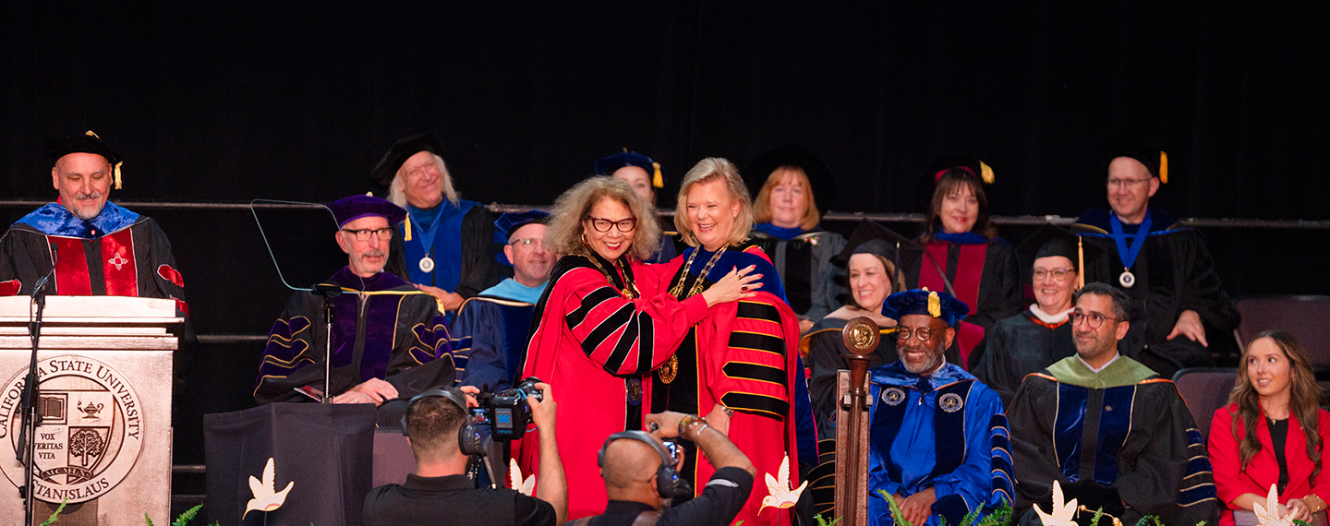 Chancellor Garcia and President Rios-Ellis pose for a picture on stage. 
