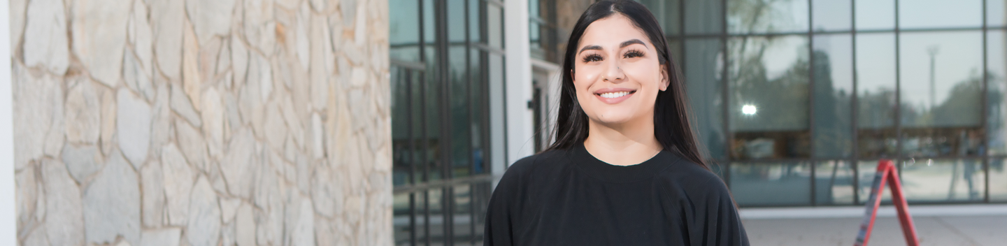 Mischelle Martinez smiling in front of the Library